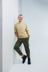 Fototapeta premium A young handsome man in casual clothes poses on a white background in the studio