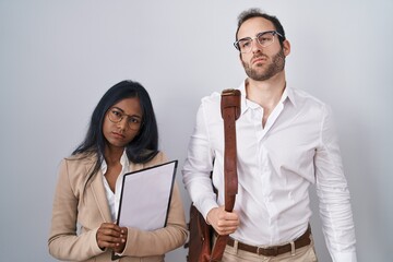 Interracial business couple wearing glasses looking sleepy and tired, exhausted for fatigue and hangover, lazy eyes in the morning.