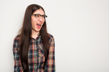 Young caucasian woman isolated on white background shouting very angry, rage concept, frustrated.