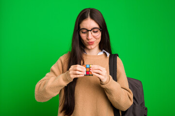 Young long hair brunette woman playing with a classic puzzle game isolated