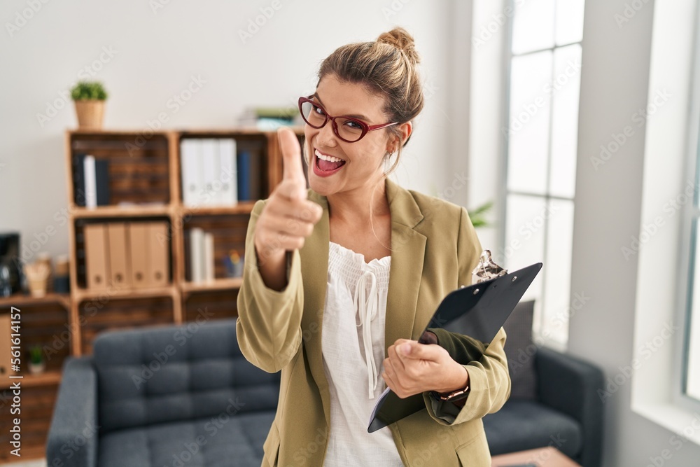 Poster young woman working at consultation office pointing fingers to camera with happy and funny face. goo