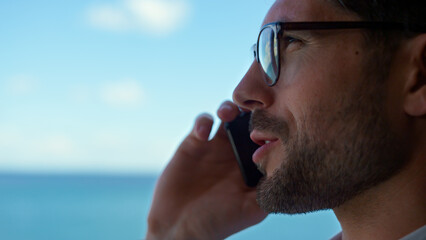 Closeup man talking phone ocean view. Businessman holding mobile conversation