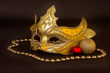 Yellow carnival mask with beads on a black background.