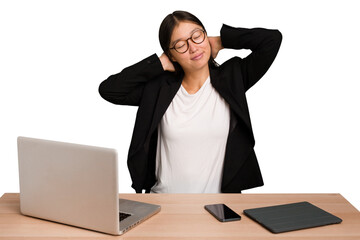 Young business asian woman sitting on a table isolated feeling confident, with hands behind the head.