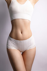 Fototapeta na wymiar Tanned woman in great shape, perfect body shape. Parts of a female body in underwear, studio shot.