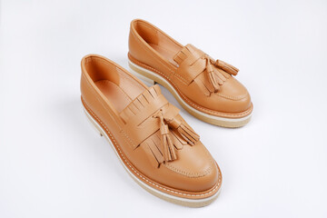 Leather women's light brown shoes highlighted on a white background.Sale of seasonal women's classic shoes, shoes in business style, for school,for teenagers.Care of genuine leather shoes, repair shop