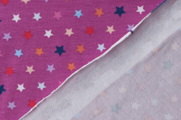 Face and back side of purple textile with stars.