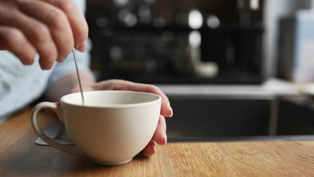 Girl hand stiring coffee cappuccino in cup