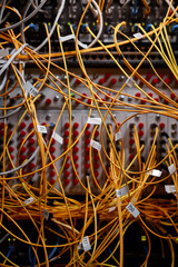 Vertical background image of server cabinet with yellow internet cables and wires connected to ports, copy space