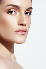 Fototapeta premium Young Caucasian girl with perfect glowing skin and natural makeup in close-up