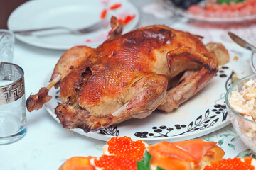 Homemade delicious baked chicken or turkey with apple and other food on the holiday table