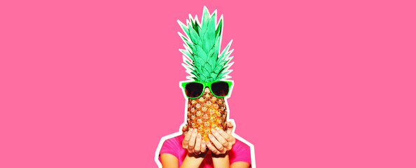 Fashion portrait woman covering her head and holding pineapple with sunglasses on colorful pink...