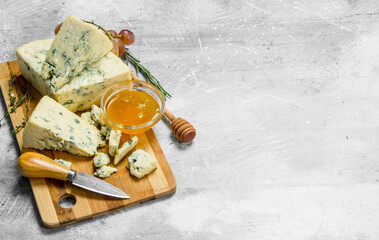 Obraz na płótnie Canvas Blue cheese with honey on a wooden Board.