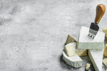 Blue and brie cheese with knives.