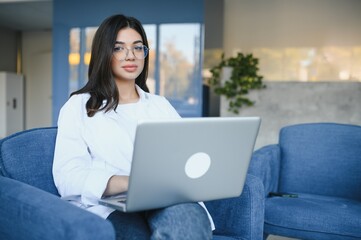 Joyful girl student studying online at cafe, using laptop and earphones, empty space