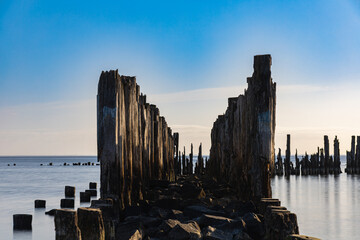 Beautiful landscape of coast of Baltic sea and old wooden breakwater at sunny cloudy morning