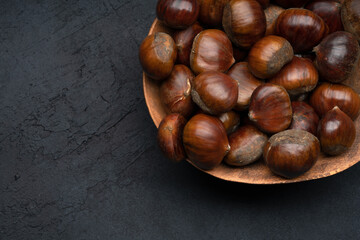 Raw roasted chestnuts on black background	