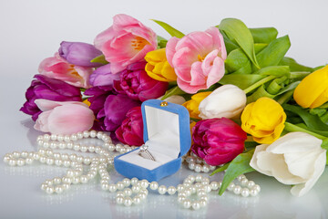 Box with luxury engagement ring and bouquet of tulips. Congratulations on Valentine's Day, birthday, engagement, wedding. Gift for girlfriend, woman.