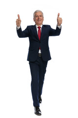 businessman walking towards the camera and giving a thumbs up