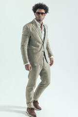 curly hair man with sunglasses walking and being confident