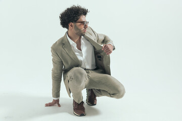 attractive turkish man looking to side while pulling suit