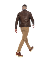 Naklejka premium back view of cool casual man looking away and walking