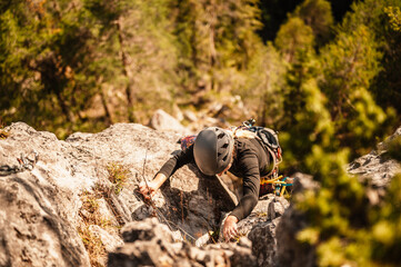 Climber wearing in climbing equipment. Practicing rock-climbing on a rock  mountain wall. Climbing...