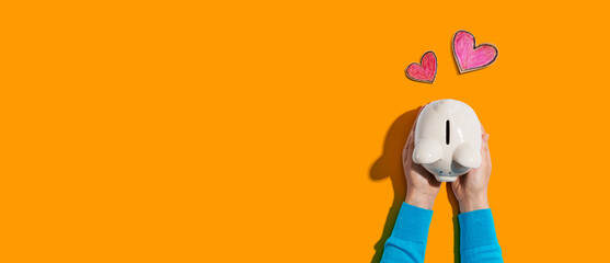 Person holding a piggy bank with hearts