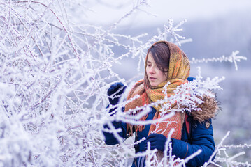 girl portrait Conception of winter holidays. park Cheerful girl in warm orange  clothes playing with snow outdoors near the beautiful forest blue  snowy branch hoar Attractive young woman