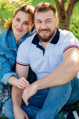 a man and a woman on a lawn in the park. romantic picnic