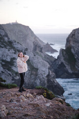 Obraz premium A woman stands on the Atlantic cliffs near Cape Roca, Sintra, Portugal.