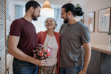Sons congratulate mom on the holiday. Men visiting their beloved mother on a holiday