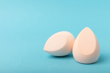 Beauty blender on blue background.Bright sponges for make-up cosmetics. Makeup products. Beauty concept. Place for text. Space for copy. Flat lay
