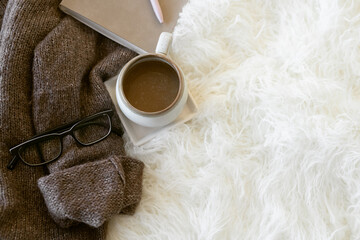 Styled Fashion Image. Dark Brown Sweater with Coffee Mug, Black Glasses, and Leather Bound...