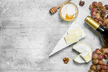 Fototapeta na wymiar Brie cheese with honey, grapes and white wine.