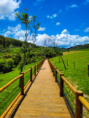 Obraz premium Wooden walkway in the contryside leading to the Buraco do Padre cave, in the state of Paraná, Brazil.