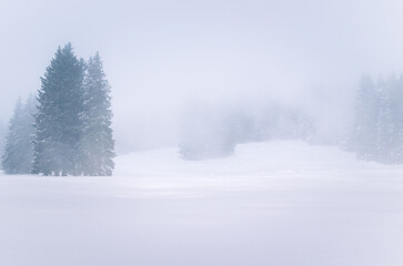 Foggy snow covered mountain lasndscape in winter. Wintry weather.