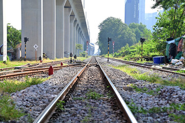 Fototapeta premium BANGKOK, THAILAND - January 15, 2023 : Railroad tracks let the train run through with nature background, Selective focus with shallow depth of field.