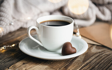 A cup of coffee and holiday sweet in the form of hearts on a wooden background, the concept of Valentine's Day.