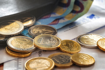 Coins euro cents with envelope with overdue household utility bills on the table. Cost of utilities...