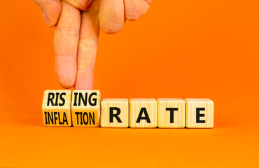 Inflation or rising rate symbol. Concept word Inflation rate Rising rate on wooden cubes. Businessman hand. Beautiful orange background. Business inflation or rising rate concept. Copy space.