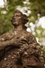 Old statue in the manor against the backdrop of trees. High quality photo