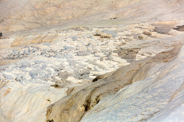 Lacy white travertine formations at hot springs of cotton castle of Pamukkale on sunny day, Turkey