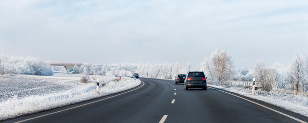 Scenic view clean intercity highway road drive cars with beautiful white covered snow trees blue...