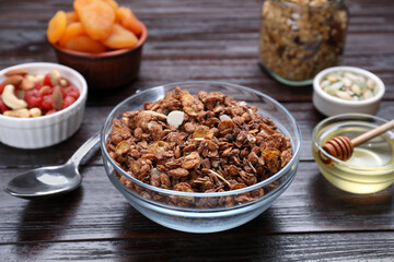 Tasty granola served with nuts, different ingredients on wooden table