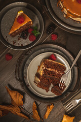 Delicious semi-naked chocolate cake with caramel topping and decorated with blackberries and raspberries. Dark background