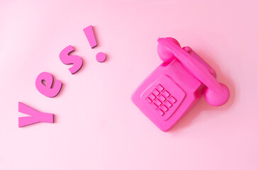 Magenta lettenext to a magenta retro phone. Minimal romantic concept for Valentine or engagement banner or card. Flat lay. Love is in the air design