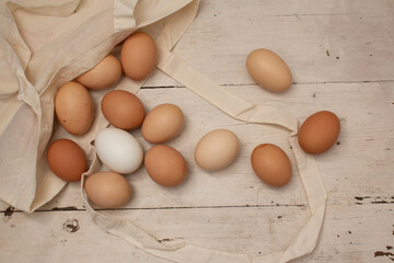 Top view. Food photography for holiday Happy Easter. Beige, white and chicken chicken eggs spilled...