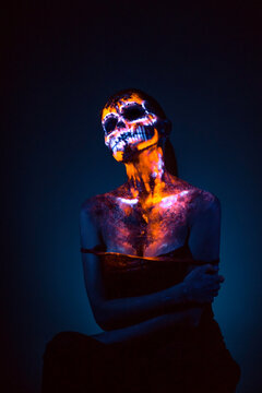 Girl's face painted UV skull
