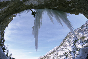 A man climbs onto an icicle.